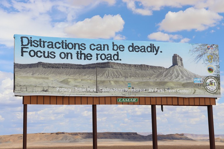 Billboard reads "Distractions can be deadly. Focus on the road."