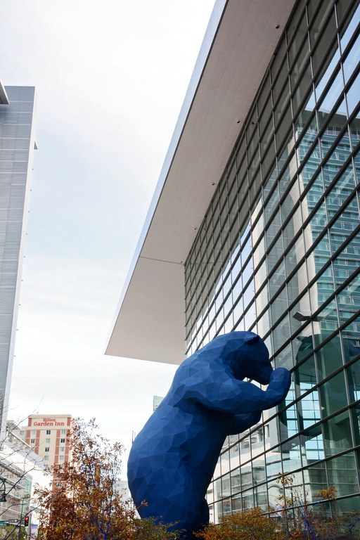 Iconic artwork featuring a 40-foot blue bear standing peering into the Denver Convention Center