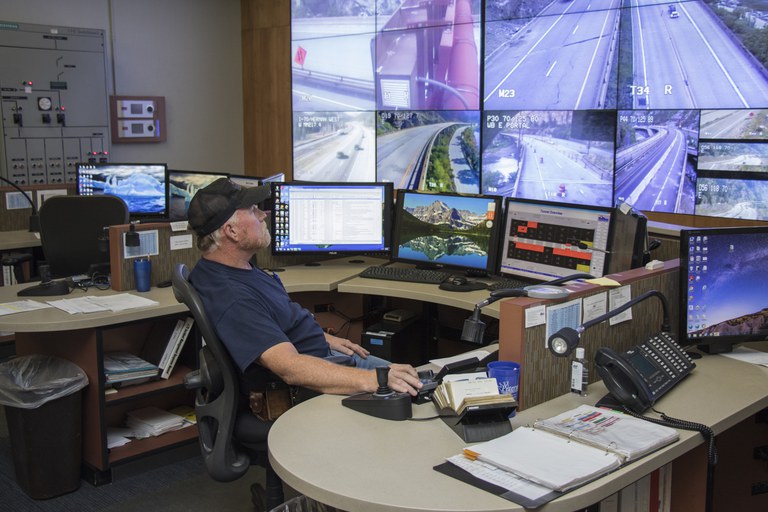 Hanging Lake Tunnel Operations Center employee looking at his computer and monitoring cameras.